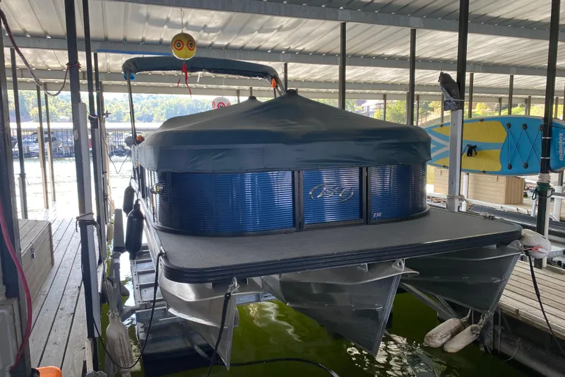 Slide: The Image of 2019 Manitou Aurora LE 23 RF VP pontoon boat docked under a covered marina. - 32