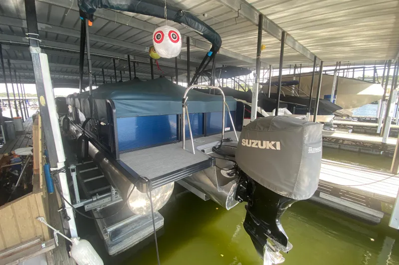 Slide: The Image of 2019 Manitou Aurora LE 23 RF VP pontoon boat with Suzuki outboard motor in covered dock. - 33