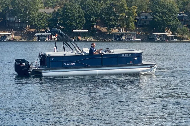 Slide: The Image of 2019 Manitou Aurora LE 23 RF VP pontoon boat on a lake with trees in the background. - 6