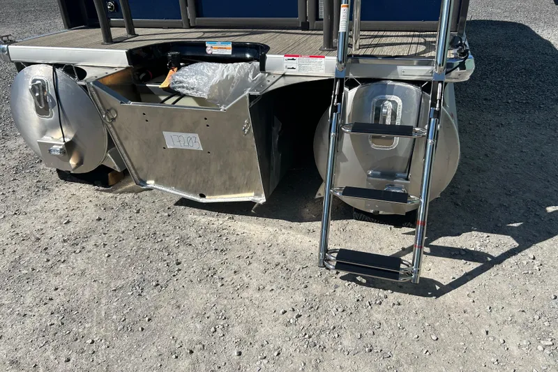 Slide: The Image of 2026 Premier 230 Solaris RF boat with ladder and storage compartment on gravel surface. - 10