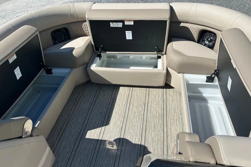 Slide: The Image of 2026 Premier 230 Solaris RF boat interior with open storage compartments and beige seating. - 14
