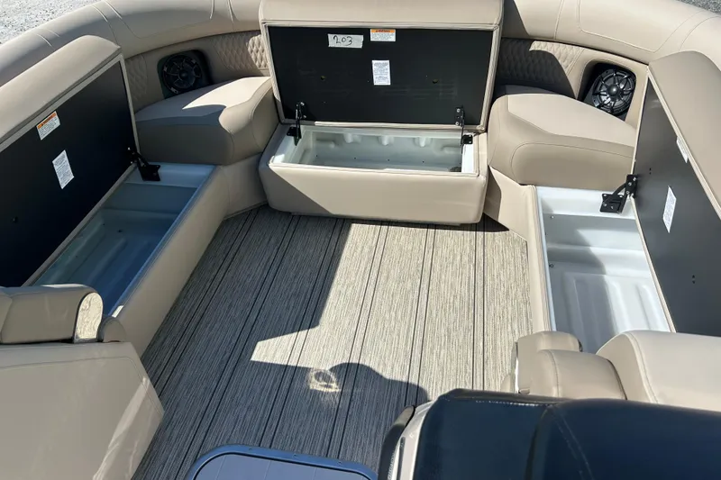Slide: The Image of 2026 Premier 230 Solaris RF boat interior with open storage compartments and beige seating. - 15