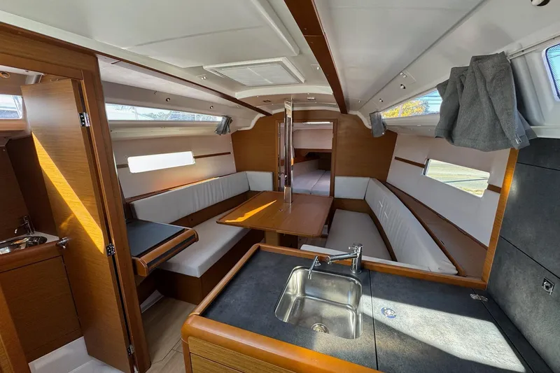 Slide: The Image of Interior of 2020 Jeanneau Sun Odyssey 349 sailboat with modern wood finish and seating area. - 14