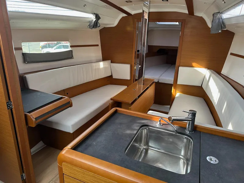 Slide: The Image of Interior of 2020 Jeanneau Sun Odyssey 349 sailboat, featuring modern seating and kitchenette. - 15