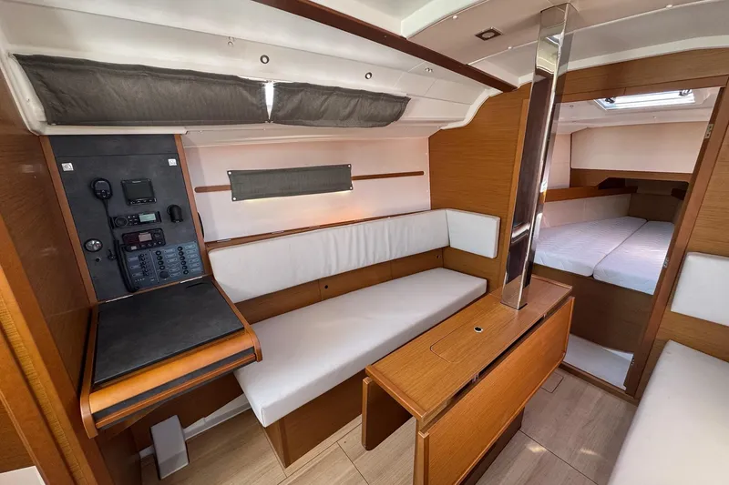 Slide: The Image of Interior of 2020 Jeanneau Sun Odyssey 349 sailboat, featuring cozy seating and navigation panel. - 21