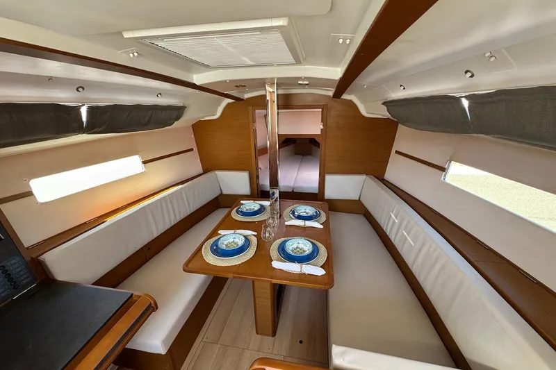 Slide: The Image of Interior of 2020 Jeanneau Sun Odyssey 349 yacht with elegant dining area setup. - 22