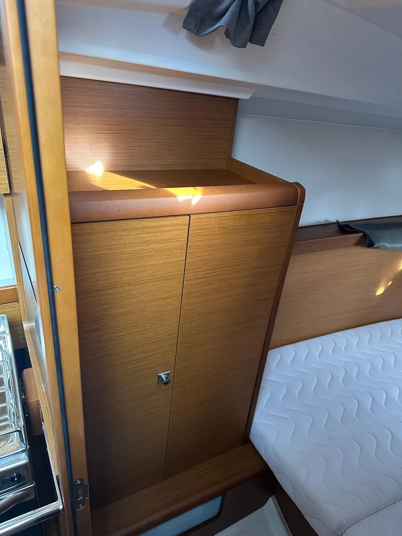Slide: The Image of Interior of 2020 Jeanneau Sun Odyssey 349, featuring wooden cabinetry and a cozy bed. - 30