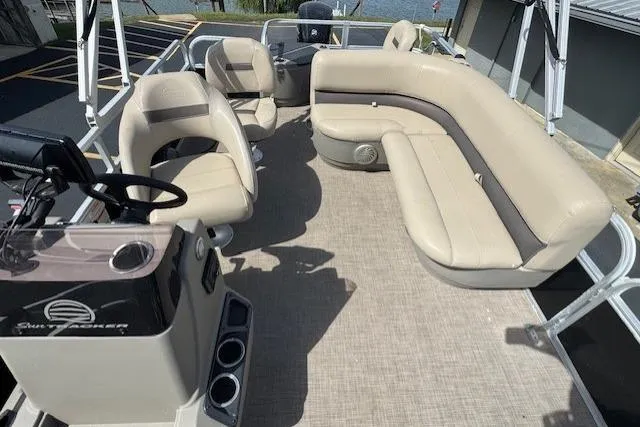 Slide: The Image of 2022 Sun Tracker Bass Buggy 18 DLX pontoon boat with beige seating and steering console. - 10