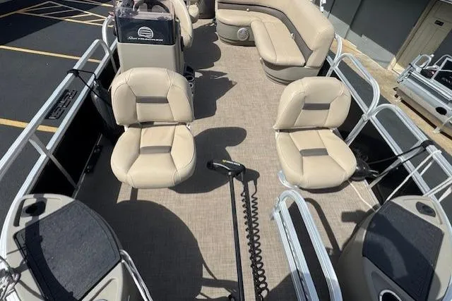 Slide: The Image of 2022 Sun Tracker Bass Buggy 18 DLX pontoon boat interior with beige seating and spacious layout. - 9