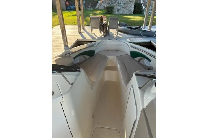 Slide: The Image of 2001 Stingray 240 LS boat interior with seating, docked near a wooden deck. - 11