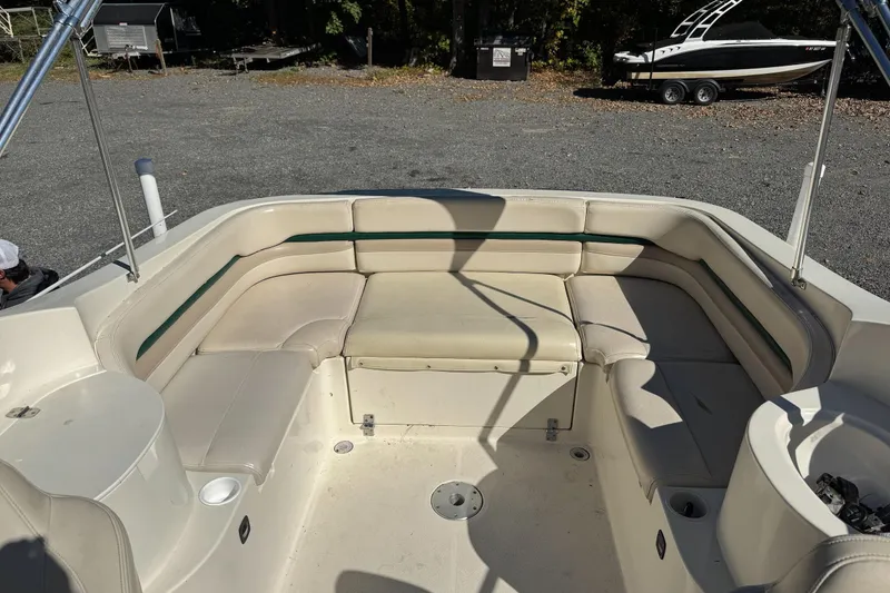 Slide: The Image of 2001 Stingray 240 LS boat interior with beige seating and green accents. - 12