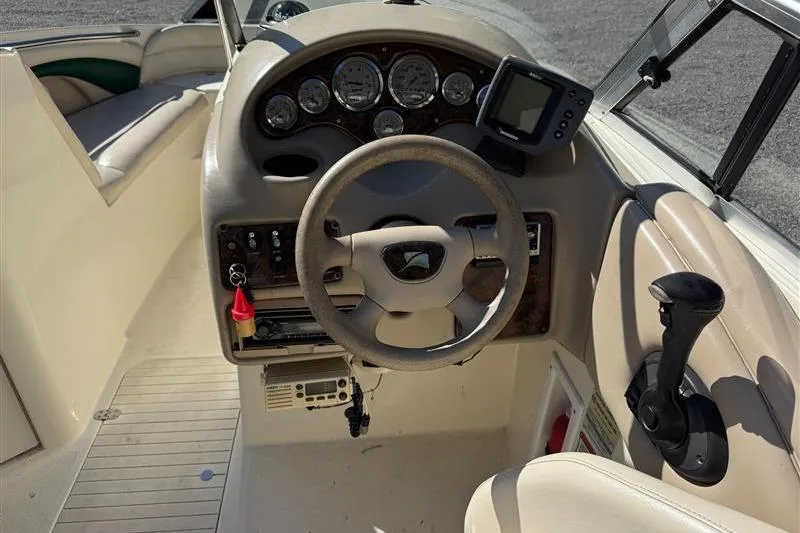 Slide: The Image of 2001 Stingray 240 LS boat dashboard with steering wheel and control panel. - 13