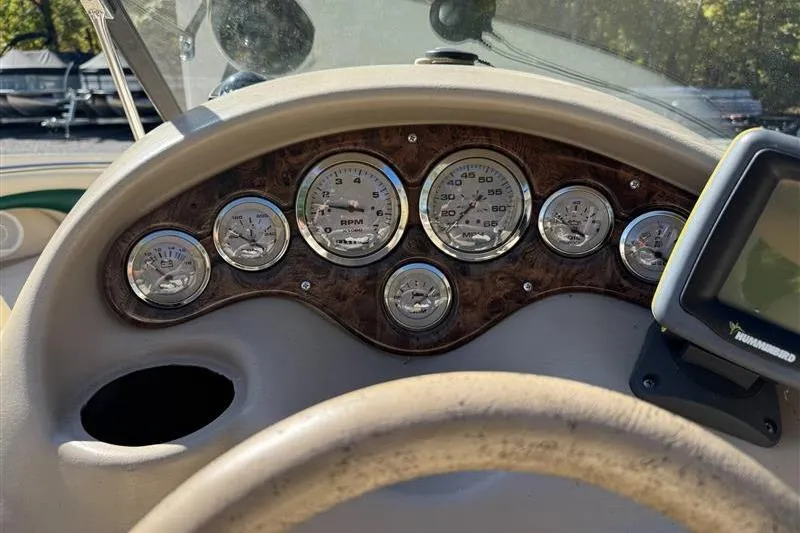 Slide: The Image of Dashboard of a 2001 Stingray 240 LS boat with gauges and a navigation device. - 14