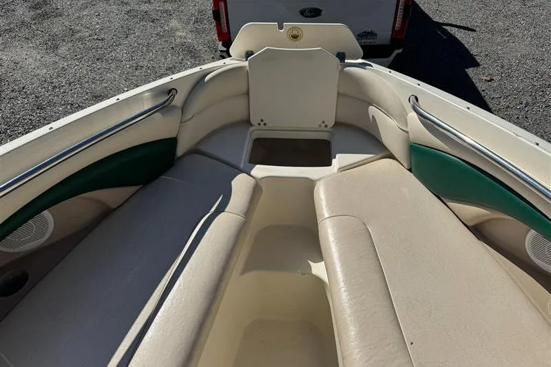 Slide: The Image of 2001 Stingray 240 LS boat interior with beige seating and green accents. - 15