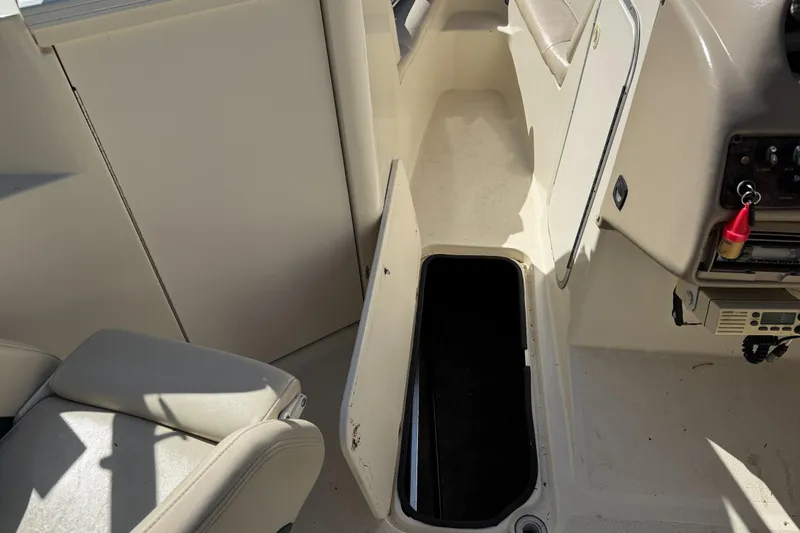 Slide: The Image of 2001 Stingray 240 LS boat interior with open storage compartment and seating. - 18