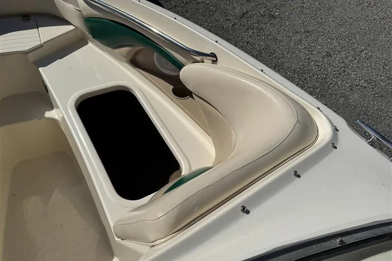 Slide: The Image of 2001 Stingray 240 LS boat interior with open storage compartment and cushioned seating. - 23