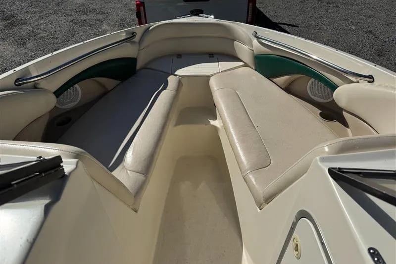 Slide: The Image of 2001 Stingray 240 LS boat interior with beige seating and green accents. - 24