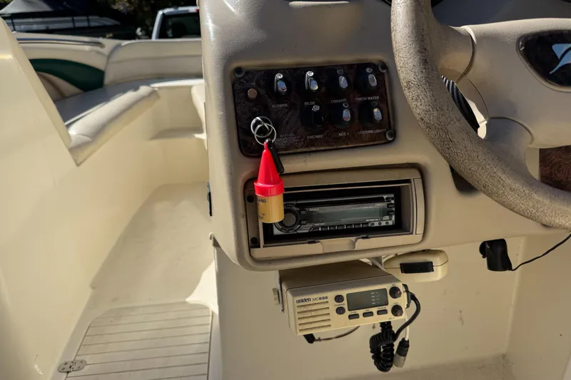 Slide: The Image of 2001 Stingray 240 LS boat dashboard with controls, steering wheel, and radio equipment. - 25