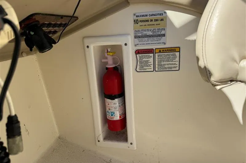 Slide: The Image of Fire extinguisher and safety labels inside 2001 Stingray 240 LS boat. - 26