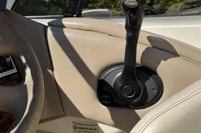 Slide: The Image of 2001 Stingray 240 LS boat throttle control on beige interior panel. - 29