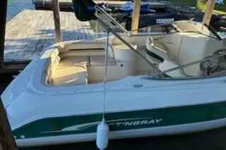 Slide: The Image of 2001 Stingray 240 LS boat docked, featuring white and green exterior with beige interior. - 4