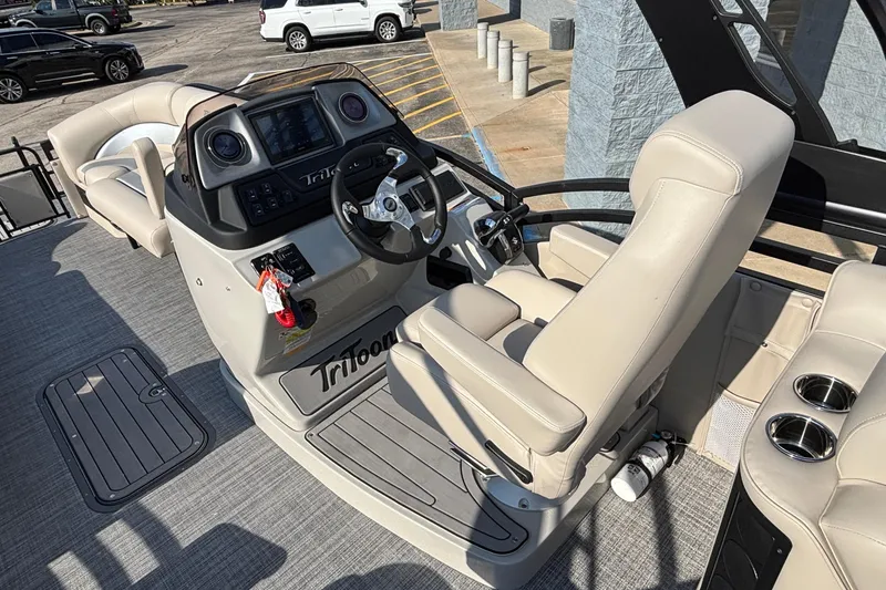 Slide: The Image of 2026 JC Neptoon 25TT Sport boat interior with steering console and beige seating. - 17