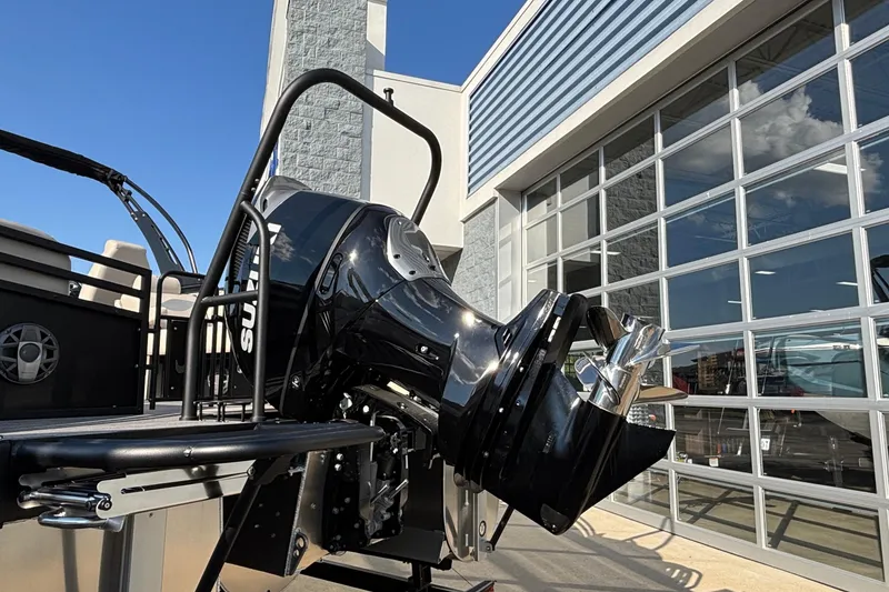 Slide: The Image of 2026 JC Neptoon 25TT Sport boat with powerful outboard motor, parked near modern building. - 32