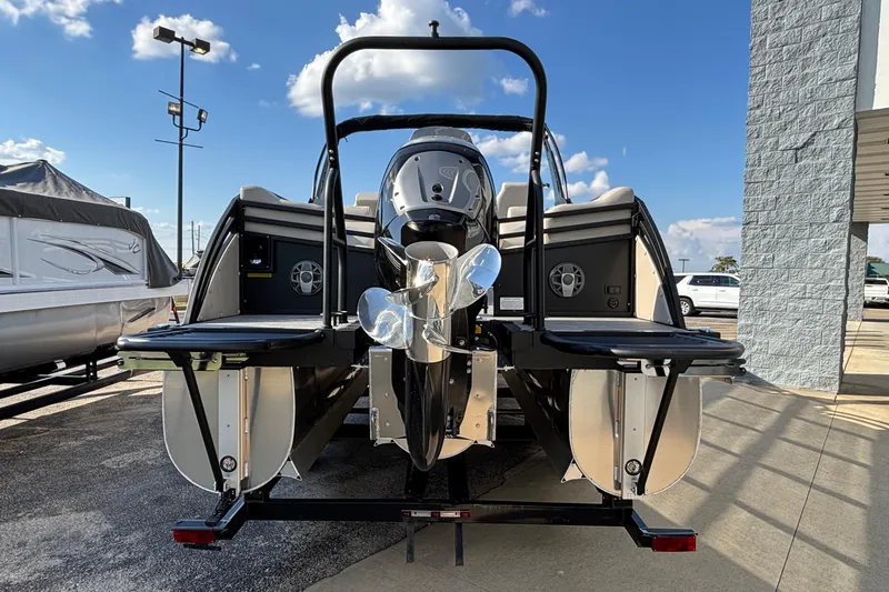 Slide: The Image of 2026 JC Neptoon 25TT Sport pontoon boat, rear view with motor, parked outdoors. - 4
