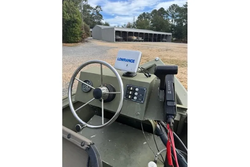 Slide: The Image of 2018 Encore Boat Works 18 with Lowrance navigation system, parked near storage facility. - 6