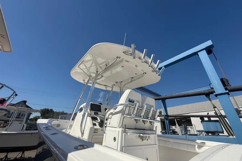 Slide: The Image of 2017 Regulator 25 boat with T-top and rod holders under clear blue sky. - 13