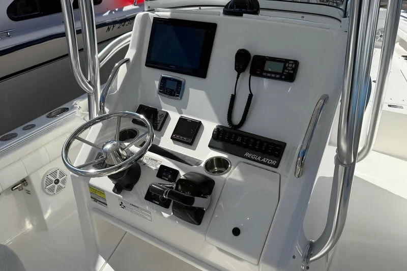 Slide: The Image of Control panel of a 2017 Regulator 25 boat with steering wheel and navigation equipment. - 22