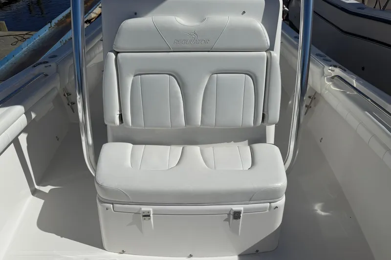 Slide: The Image of 2017 Regulator 25 boat seat with white cushioned upholstery and stainless steel frame. - 28