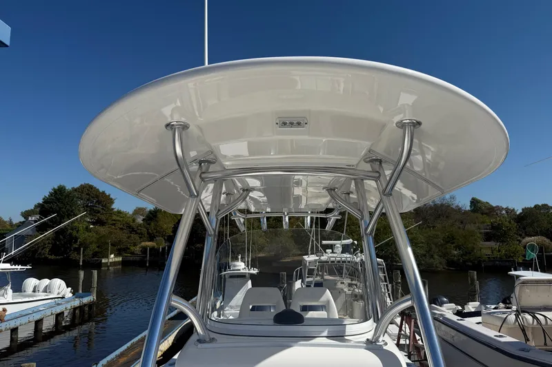 Slide: The Image of 2017 Regulator 25 boat with T-top, docked in a serene marina setting. - 29