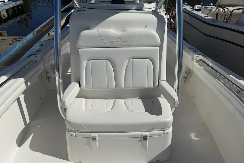 Slide: The Image of 2017 Regulator 25 boat seat with white upholstery and stainless steel frame. - 30