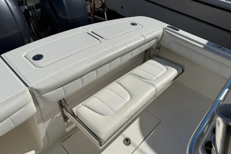 Slide: The Image of 2017 Regulator 25 boat with white cushioned seating and storage compartments. - 36