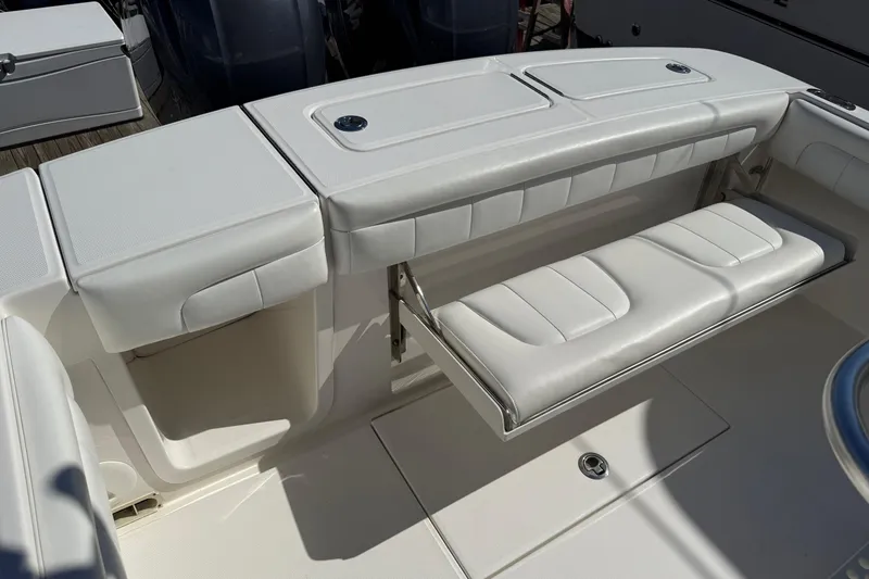 Slide: The Image of 2017 Regulator 25 boat with white cushioned seating and storage compartments. - 37