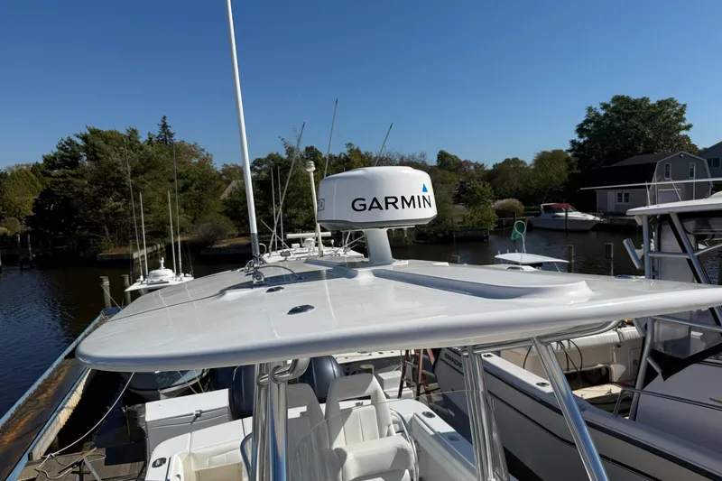 Slide: The Image of 2017 Regulator 25 boat with Garmin radar, docked in a serene marina setting. - 38
