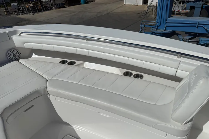 Slide: The Image of 2017 Regulator 25 boat interior with white cushioned seating and cup holders. - 42