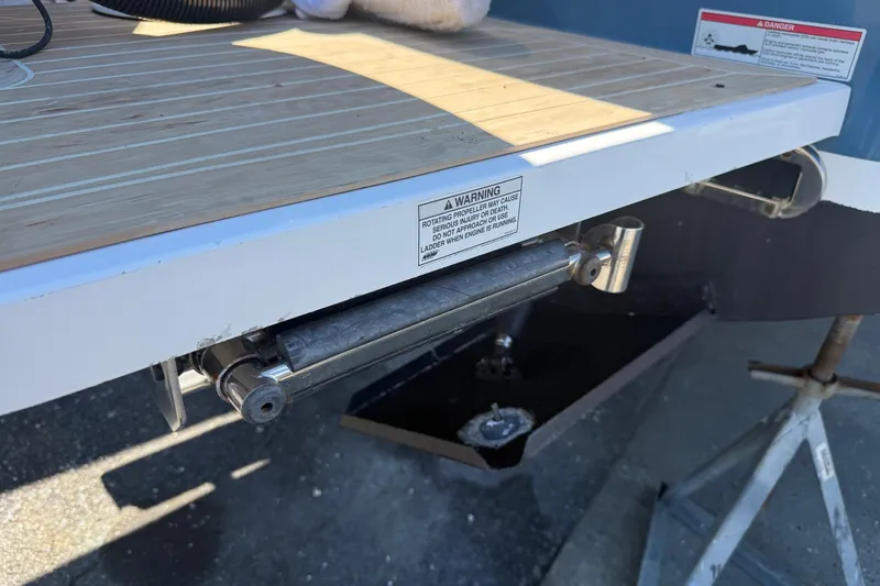 Slide: The Image of 2017 Regulator 25 boat swim platform with warning label and ladder mechanism. - 43