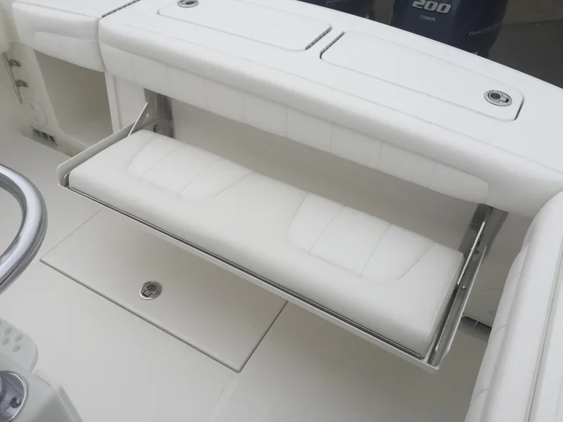 Slide: The Image of 2017 Regulator 25 boat with white cushioned seating and storage compartment. - 7