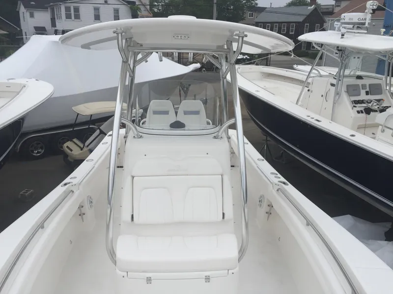 Slide: The Image of 2017 Regulator 25 boat with T-top and seating, docked among other boats. - 8