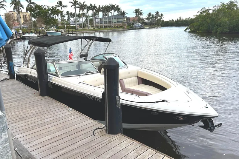 Slide: The Image of 2010 Cobalt 296 boat docked on a serene waterfront with palm trees. - 1