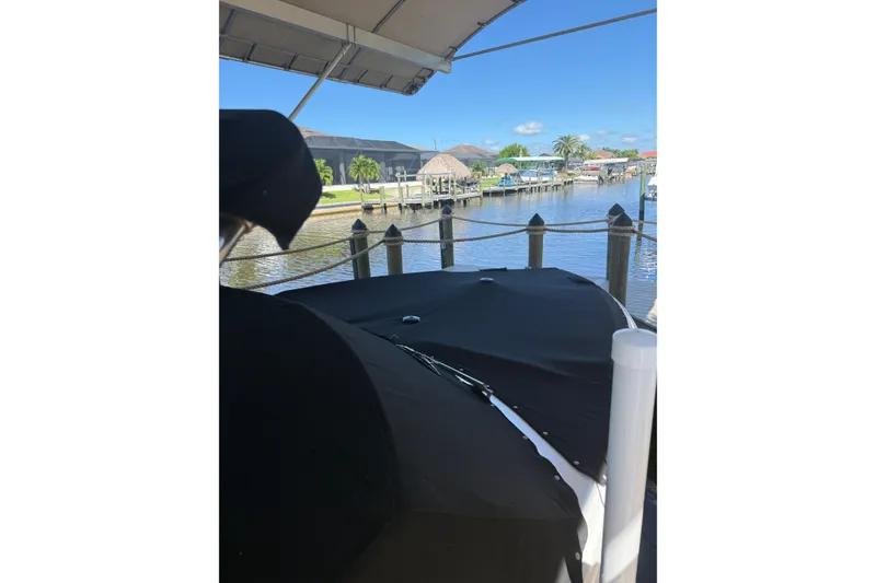 Slide: The Image of Covered 2010 Cobalt 296 boat docked by a scenic waterfront. - 10