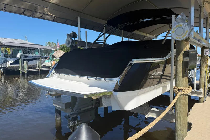 Slide: The Image of 2010 Cobalt 296 boat docked under a canopy, covered and elevated above water. - 11