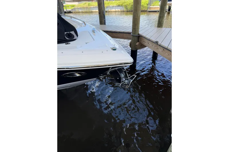 Slide: The Image of 2010 Cobalt 296 boat docked in calm waters near a wooden pier. - 12