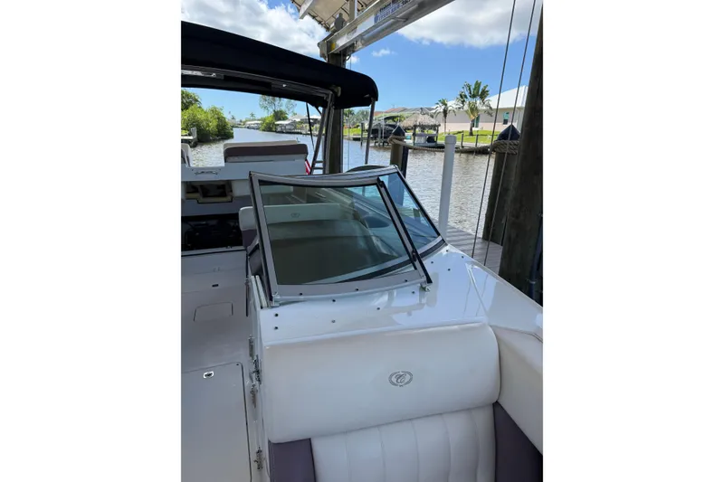Slide: The Image of 2010 Cobalt 296 boat interior with white seating, docked by a canal. - 17