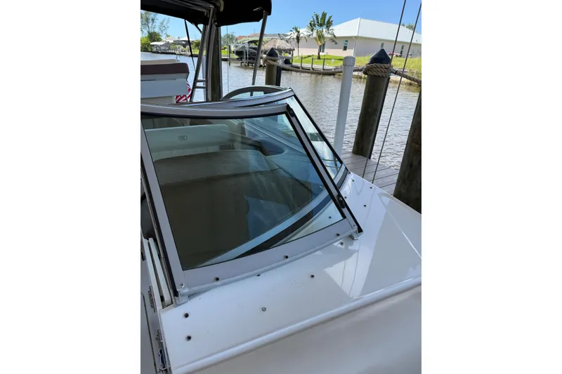 Slide: The Image of 2010 Cobalt 296 boat windshield and deck, docked by a calm waterfront. - 18
