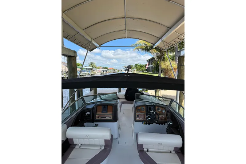 Slide: The Image of Interior view of a 2010 Cobalt 296 boat under a canopy, showcasing the helm and seating. - 24