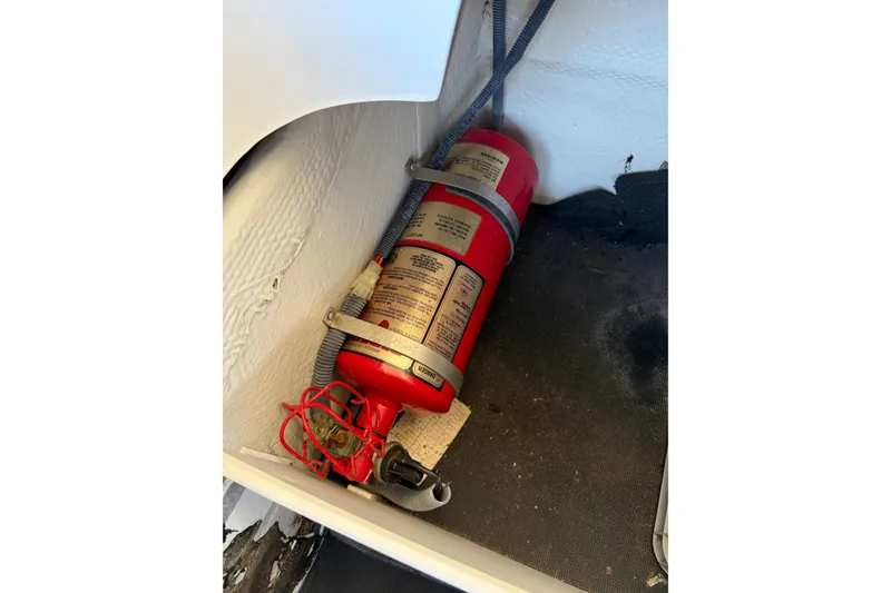 Slide: The Image of Red fire extinguisher mounted in a 2010 Cobalt 296 boat compartment. - 29