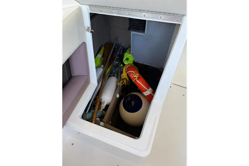 Slide: The Image of Storage compartment of a 2010 Cobalt 296 boat with safety equipment and gear. - 33